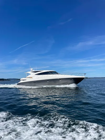 Phantom Of The Sea Yacht Photos Pics 2013 Riviera 5800 Sport Yacht cruising on open water under clear blue skies.