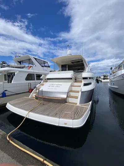 Phantom Of The Sea Yacht Photos Pics 2013 Riviera 5800 Sport Yacht docked at marina under blue sky.