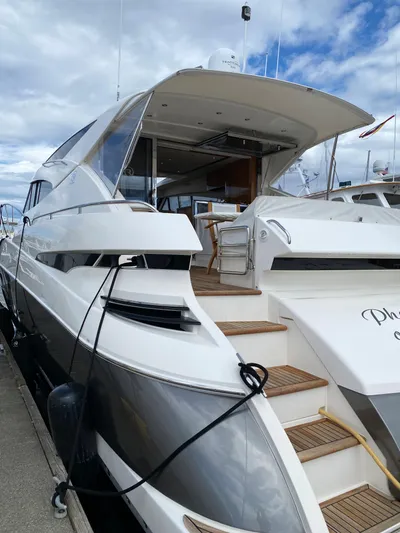 Phantom Of The Sea Yacht Photos Pics 2013 Riviera 5800 Sport Yacht docked, showcasing sleek design and spacious deck.