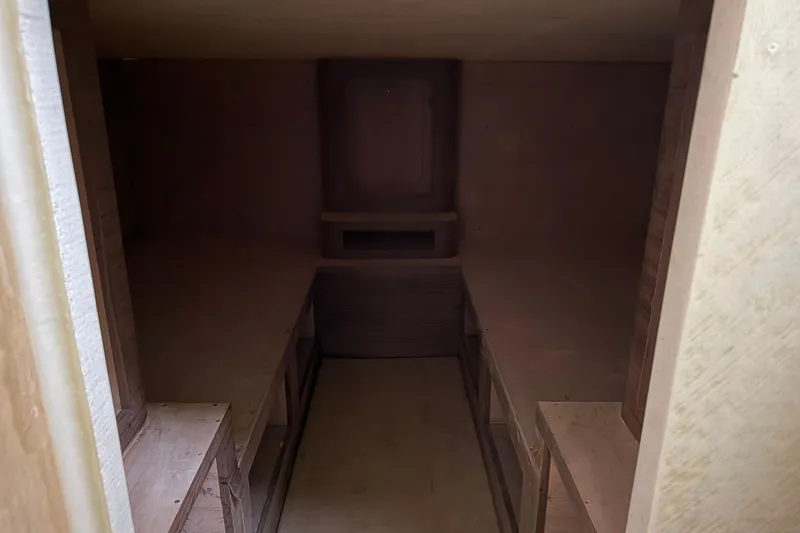 No Name Yacht Photos Pics Interior of 2025 Xcelerator Walk Around boat, unfinished wooden cabin space.