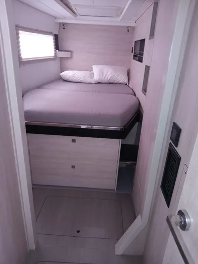 Marylee Yacht Photos Pics Compact bedroom in a 2020 Leopard 45 catamaran with a cozy bed and storage.