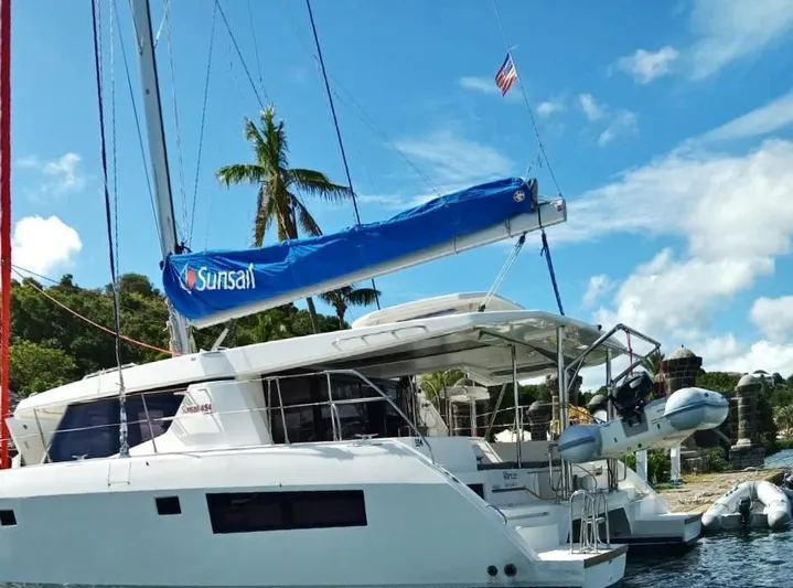 Marylee Yacht Photos Pics Leopard 45 catamaran yacht docked, 2020 model, with Sunsail branding, tropical background.