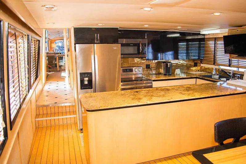 Happy Ours Yacht Photos Pics Luxurious kitchen interior of 1989 Broward 85 Raised Pilothouse yacht with modern appliances.