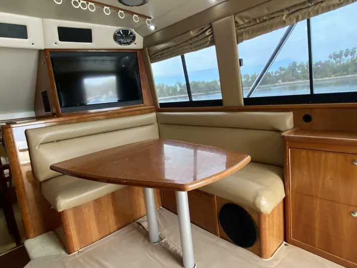 Warrior Yacht Photos Pics Interior of 2001 Riviera 43 Flybridge yacht with dining area and large windows.