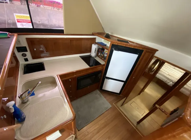 Warrior Yacht Photos Pics 2001 Riviera 43 Flybridge yacht kitchen with sink, stove, and refrigerator.