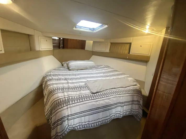 Warrior Yacht Photos Pics Cozy bedroom in 2001 Riviera 43 Flybridge yacht with patterned bedding and overhead skylight.