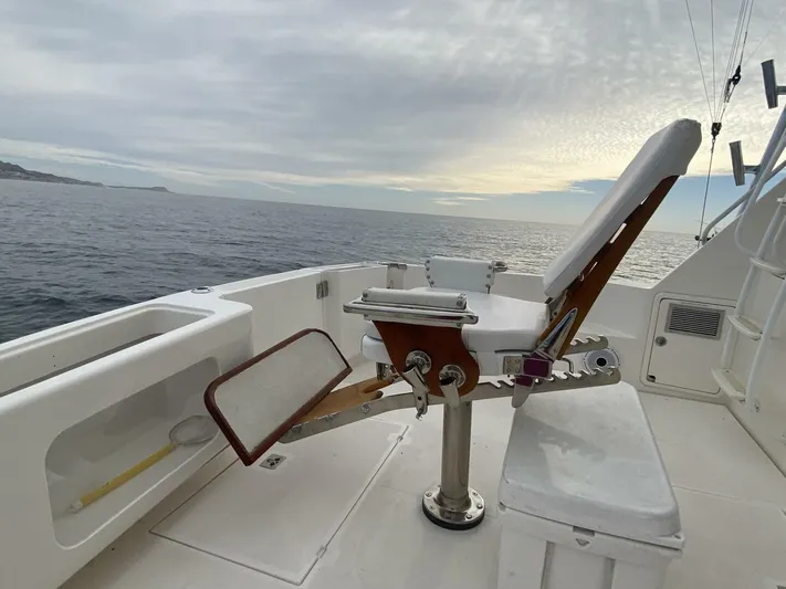 Warrior Yacht Photos Pics Riviera 43 Flybridge 2001 boat deck with fishing chair, ocean view at sunset.