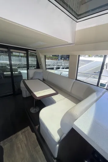 Caribbean Smile Yacht Photos Pics Interior of 2019 Regal 42 Grande Coupe yacht with white seating and dining table.