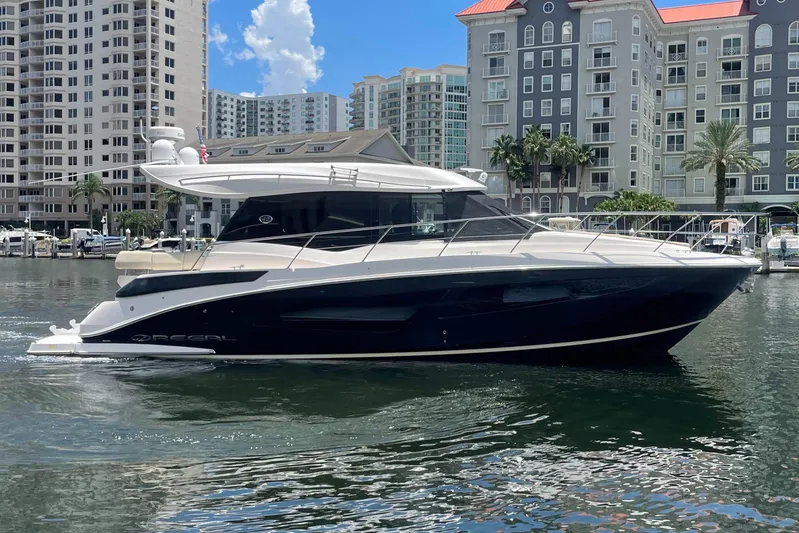 Caribbean Smile Yacht Photos Pics 2019 Regal 42 Grande Coupe yacht docked in a marina with cityscape background.