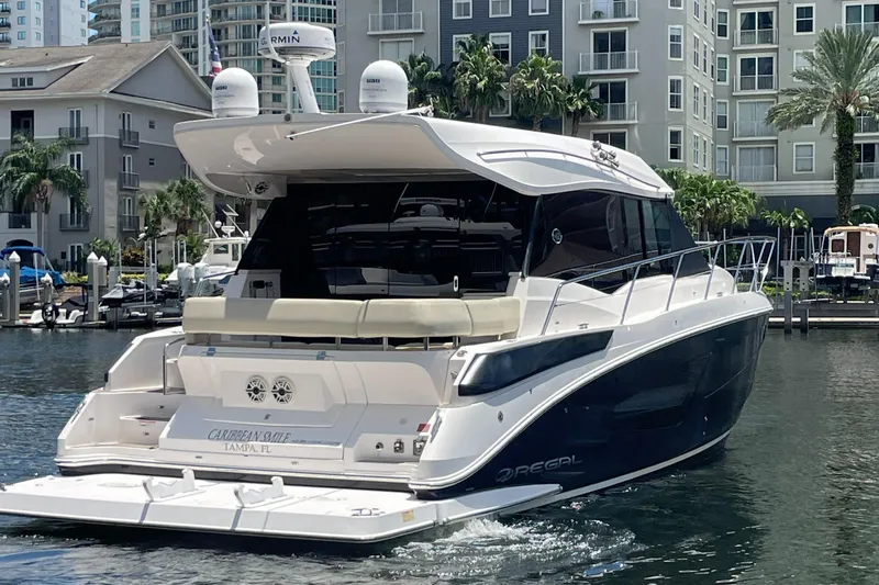 Caribbean Smile Yacht Photos Pics 2019 Regal 42 Grande Coupe yacht docked in a marina with waterfront buildings.