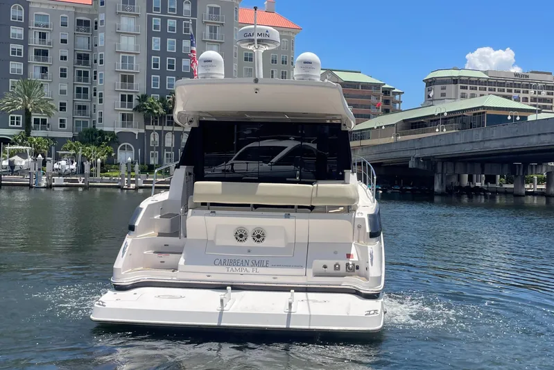 Caribbean Smile Yacht Photos Pics 2019 Regal 42 Grande Coupe yacht docked in a marina with waterfront buildings.