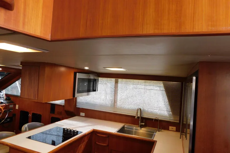 Driftwood Yacht Photos Pics Interior of 1995 Jefferson 52 Riviana Cockpit MY yacht with wooden cabinetry and modern kitchen amenities.