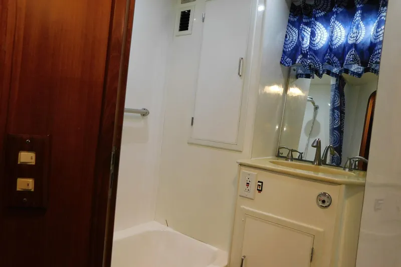 Driftwood Yacht Photos Pics Bathroom interior of 1995 Jefferson 52 Riviana Cockpit MY yacht with sink and blue curtains.