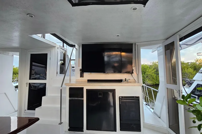 Driftwood Yacht Photos Pics Interior of 1995 Jefferson 52 Riviana Cockpit MY with TV, stairs, and outdoor view.