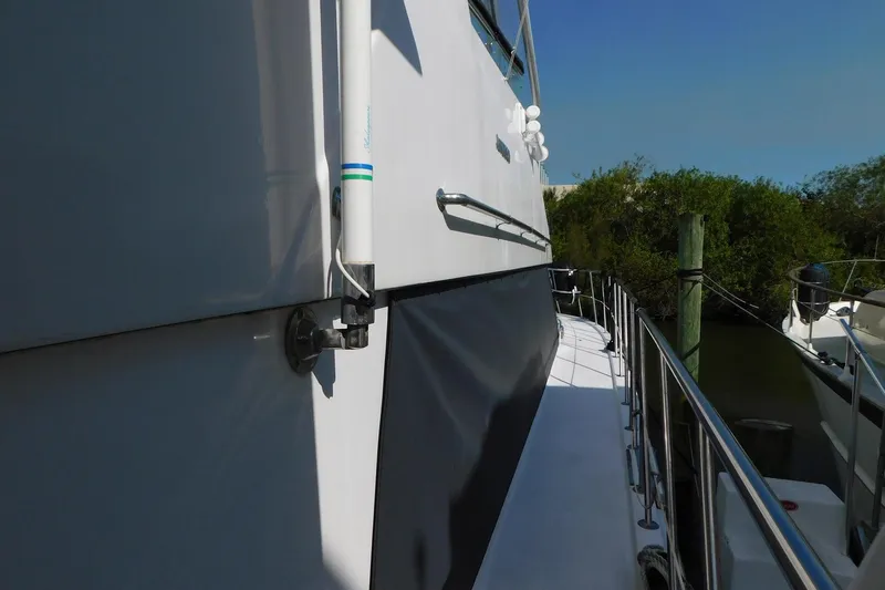 Driftwood Yacht Photos Pics Side view of 1995 Jefferson 52 Riviana Cockpit MY yacht docked by greenery.