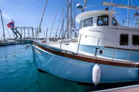 Custom 2016 trawler docked in marina, featuring blue hull and white cabin.