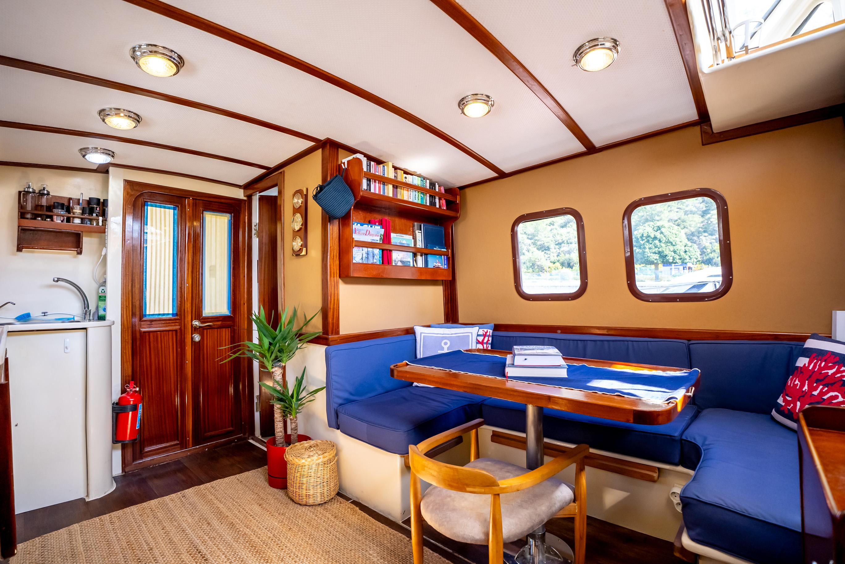 Interior of a 2016 Custom Trawler with cozy seating, wooden accents, and nautical decor.