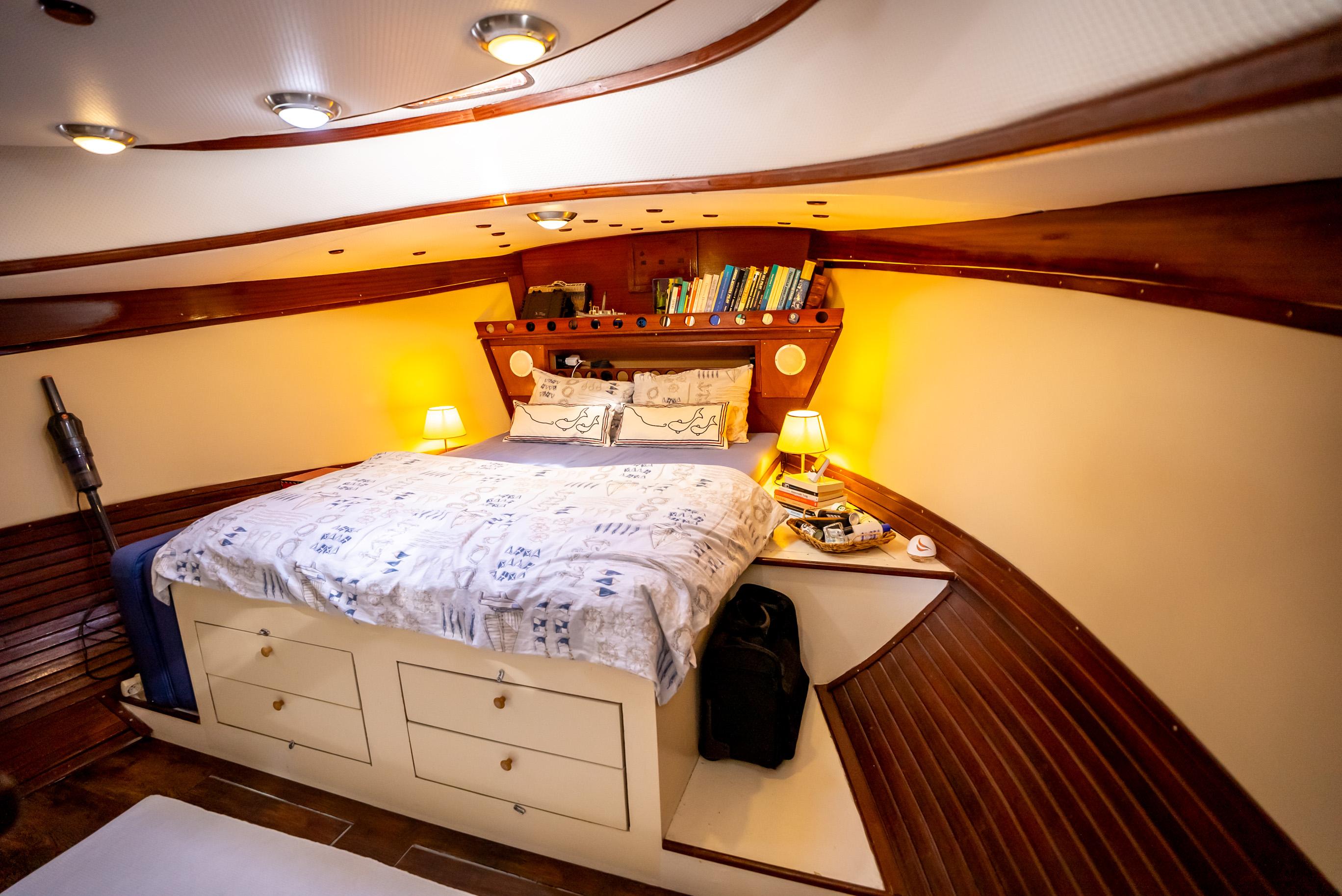 Luxurious 2016 custom trawler bedroom with cozy bed, wooden accents, and ambient lighting.
