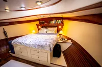 Luxurious 2016 custom trawler bedroom with cozy bed, wooden accents, and ambient lighting.