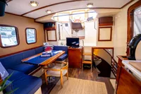 Interior of a 2016 Custom Trawler with cozy seating, dining area, and helm station.