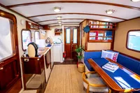 Interior of a 2016 Custom Trawler with cozy dining area and kitchenette.