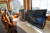 Custom 2016 Trawler helm with navigation screens and wooden steering wheel.