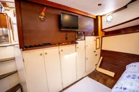 Interior of a 2016 custom trawler with TV, cabinets, and nautical decor.