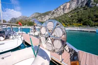 Custom 2016 trawler docked in scenic marina with mountainous backdrop.