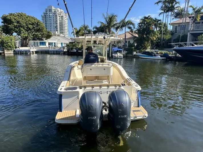 T/t Living With E's Yacht Photos Pics 2018 Scout 255LXF boat with dual engines on a sunny waterfront.