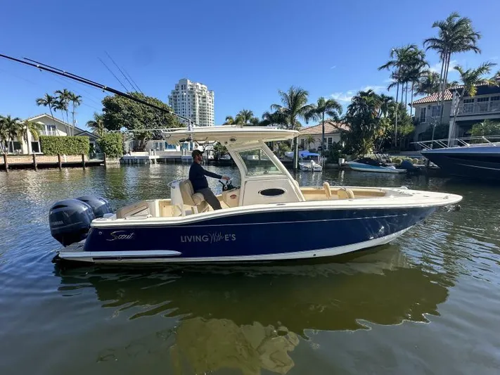 T/t Living With E's Yacht Photos Pics 2018 Scout 255LXF boat on water, surrounded by palm trees and waterfront homes.