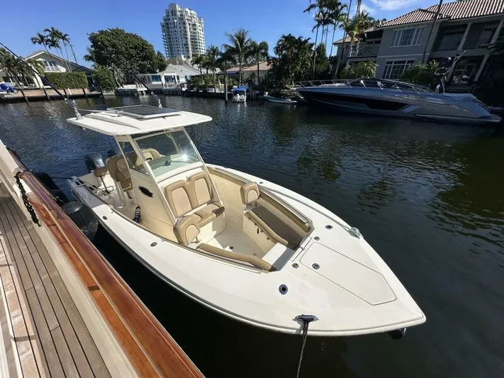 T/t Living With E's Yacht Photos Pics 2018 Scout 255LXF boat docked in a scenic canal with luxury homes.