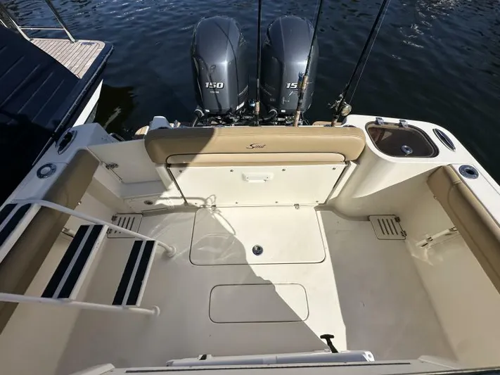 T/t Living With E's Yacht Photos Pics 2018 Scout 255LXF boat deck with twin 150 engines, spacious seating, and fishing rod holders.
