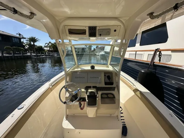 T/t Living With E's Yacht Photos Pics 2018 Scout 255LXF boat cockpit with steering wheel and Garmin navigation system.