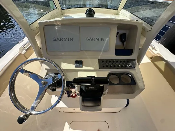 T/t Living With E's Yacht Photos Pics 2018 Scout 255LXF boat dashboard with Garmin navigation system and steering wheel.