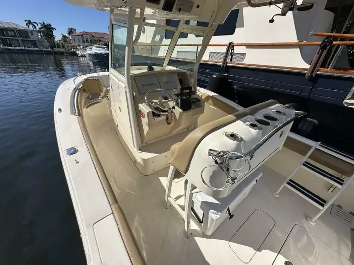 T/t Living With E's Yacht Photos Pics 2018 Scout 255LXF boat interior with helm and seating, docked by waterfront homes.
