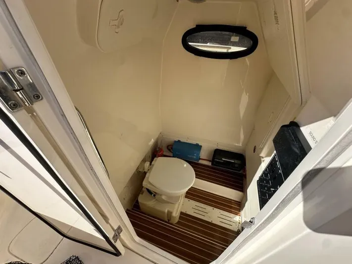 T/t Living With E's Yacht Photos Pics 2018 Scout 255LXF boat interior bathroom with toilet and wooden flooring.