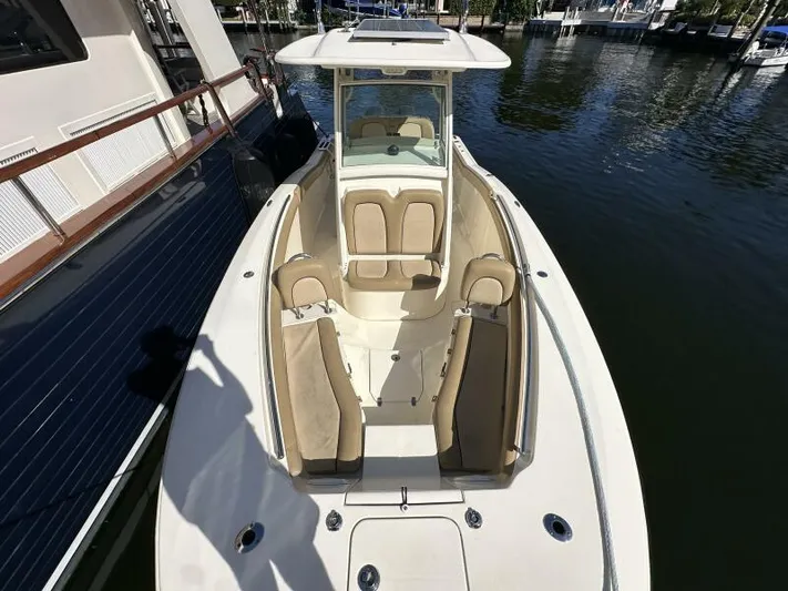 T/t Living With E's Yacht Photos Pics 2018 Scout 255LXF boat with beige seating, docked on calm water.