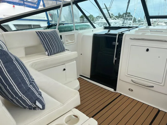 "salty Dog" Yacht Photos Pics Interior of 2000 Tiara Yachts 4100 Open, featuring striped cushions and teak flooring.