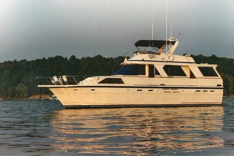  Yacht Photos Pics 1990 Jefferson 52 Marquessa ED yacht on calm water with forested background.