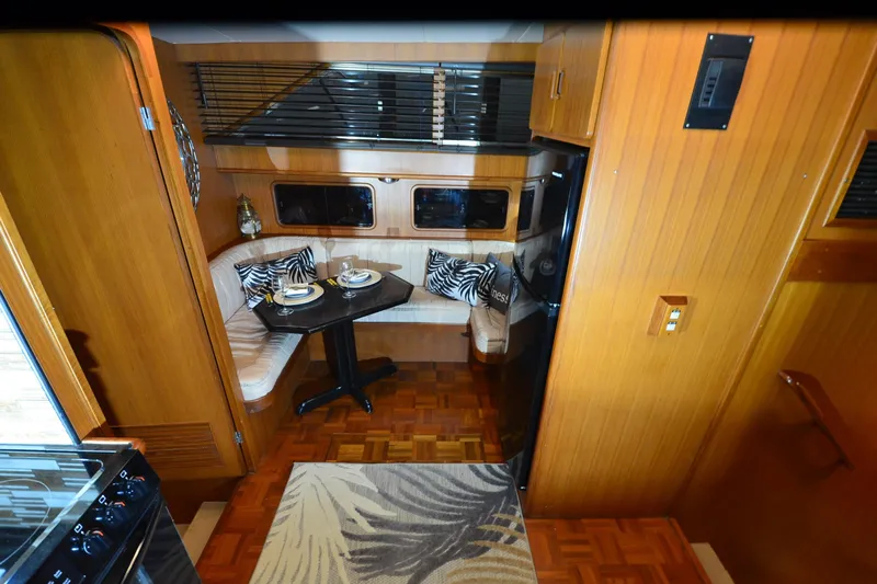  Yacht Photos Pics Cozy dining area in 1990 Jefferson 52 Marquessa ED yacht with wood paneling and zebra-patterned cushions.