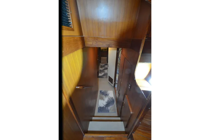  Yacht Photos Pics Interior view of 1990 Jefferson 52 Marquessa ED yacht with wooden paneling and carpeted stairs.