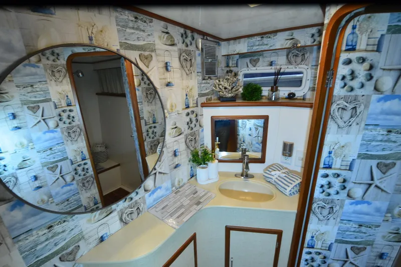  Yacht Photos Pics Nautical-themed bathroom in a 1990 Jefferson 52 Marquessa ED yacht, featuring decorative wallpaper.