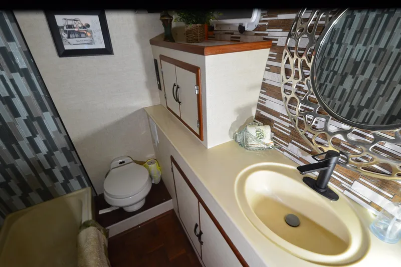  Yacht Photos Pics Bathroom interior of 1990 Jefferson 52 Marquessa ED yacht with modern sink and decorative mirror.