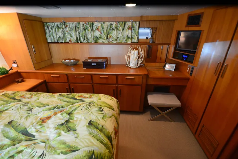  Yacht Photos Pics Luxurious 1990 Jefferson 52 Marquessa ED yacht bedroom with tropical decor and wooden cabinetry.