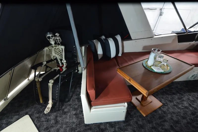  Yacht Photos Pics Skeleton seated on a 1990 Jefferson 52 Marquessa ED yacht with table setting.