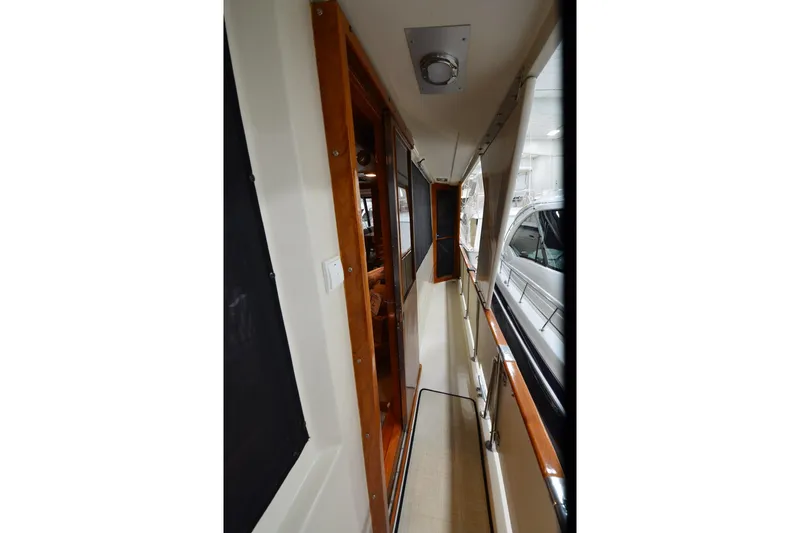  Yacht Photos Pics Narrow corridor on 1990 Jefferson 52 Marquessa ED yacht with wooden accents and windows.