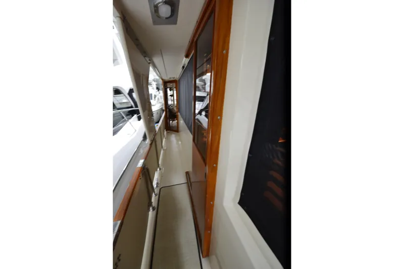  Yacht Photos Pics Narrow walkway on 1990 Jefferson 52 Marquessa ED yacht with wooden trim and windows.