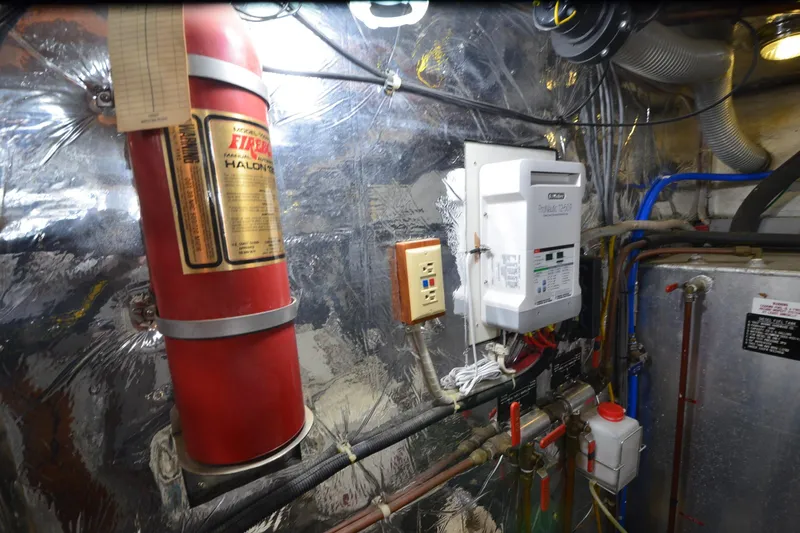  Yacht Photos Pics Engine room of 1990 Jefferson 52 Marquessa ED with fire extinguisher and control panel.