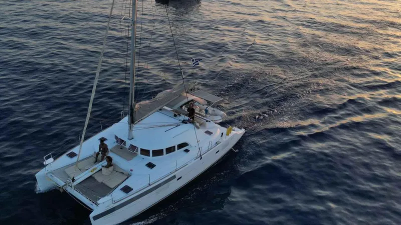 Sunny Days Yacht Photos Pics 2013 Lagoon 380 S2 catamaran sailing at sunset on calm waters.