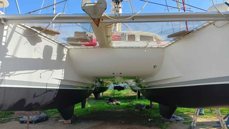 Sunny Days Yacht Photos Pics 2013 Lagoon 380 S2 catamaran on land, showcasing hull and netting.